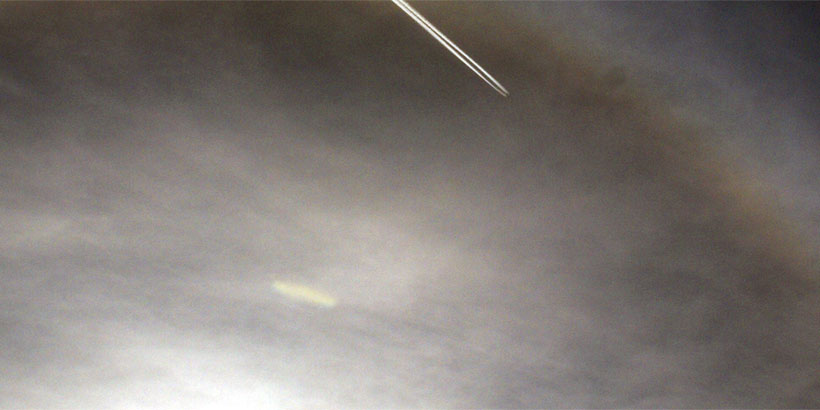 Cigar-shaped UFO and airplane in Sun halo